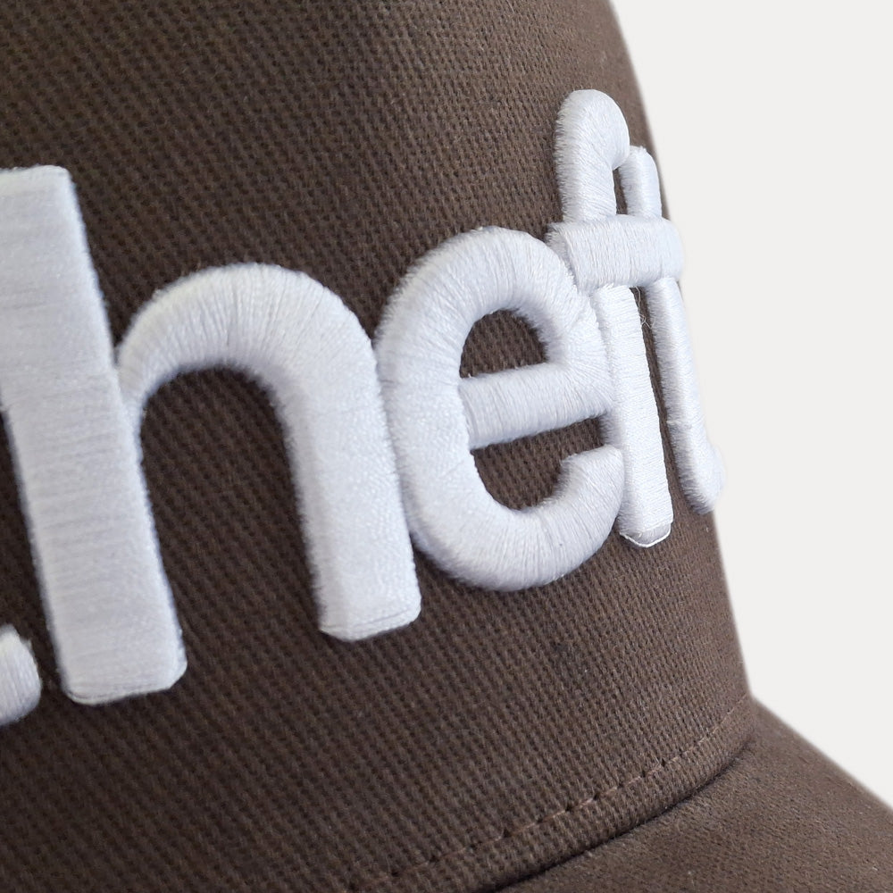 Wordmark trucker cap front detail view